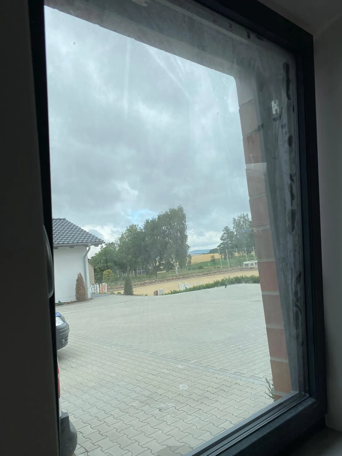 Fensterscheibe mit Bauschmutz und Schlieren vor der Reinigung